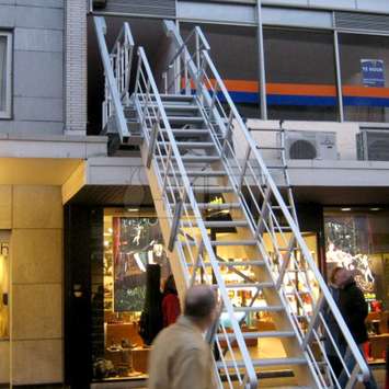 Gebalanceerde klaptrap Evacuatietrappen die uit de façade van een gebouw glijden voordat deze soepel op de grond zwenken.